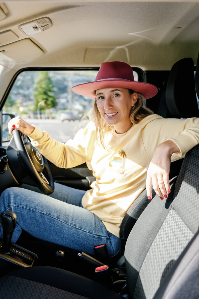 Roxanne zit in een auto bij Maidens Cove in Kaapstad, Zuid-Afrika