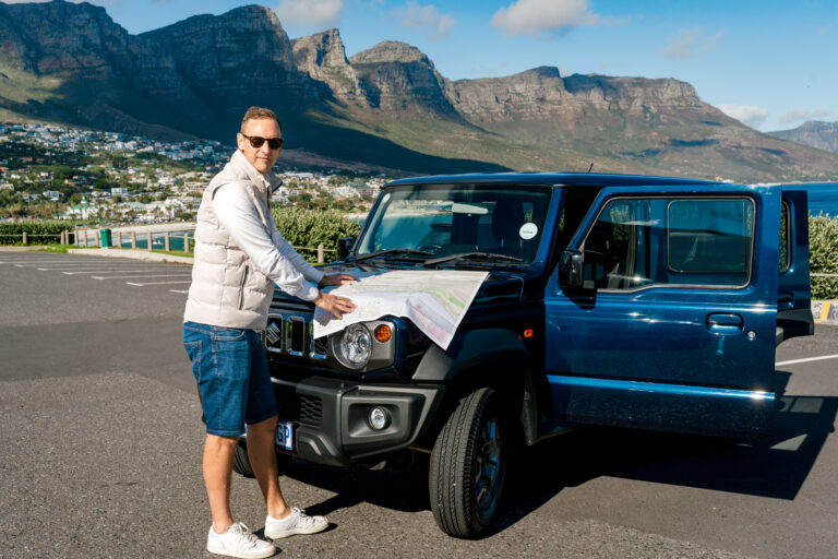 Autorijden in Zuid-Afrika: Roxanne naast een huurauto tijdens een self drive in Kaapstad