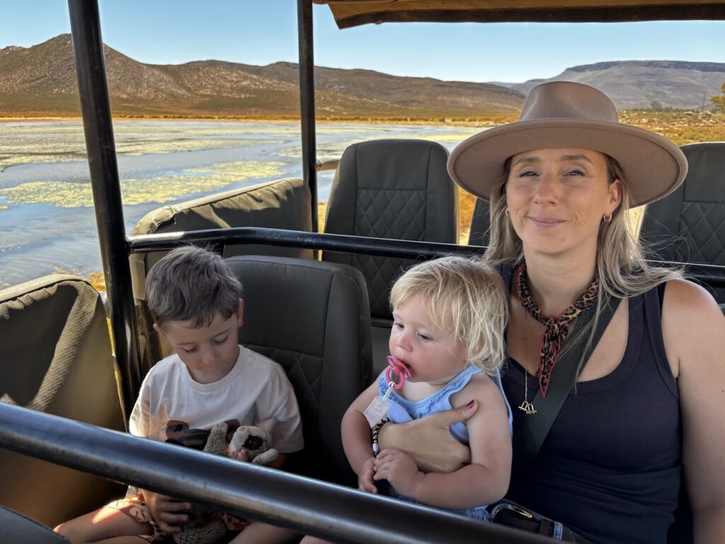 Een gezin geniet van een safari in een open safari-jeep tijdens een kindvriendelijke en malariavrije safari in Zuid-Afrika.