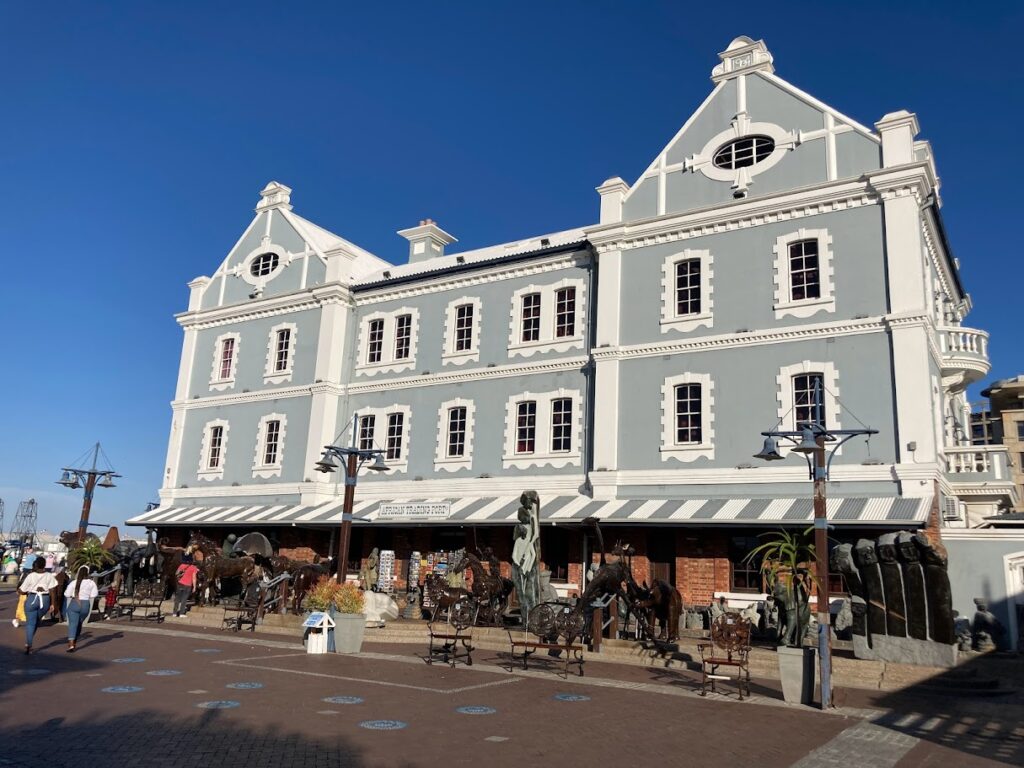 Historisch gebouw bij de V&A Waterfront in Kaapstad met winkels en terrassen.