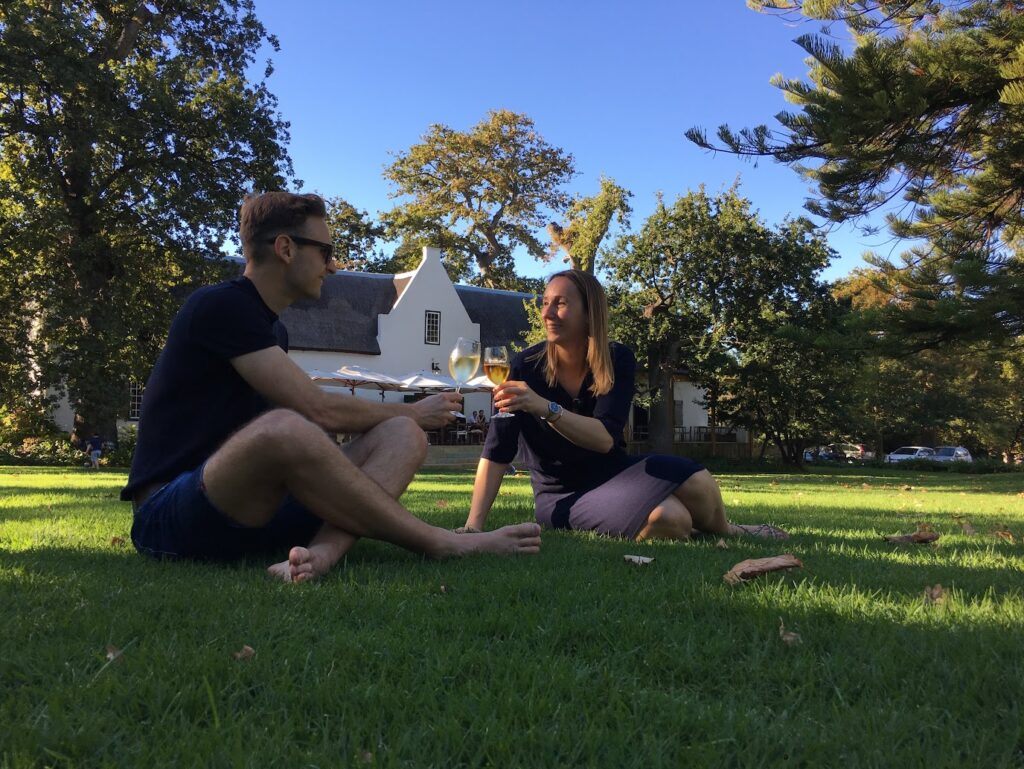 Joey en Roxanne proosten met een glas wijn bij wijnhuis Buitenverwachting in Constantia, Kaapstad.