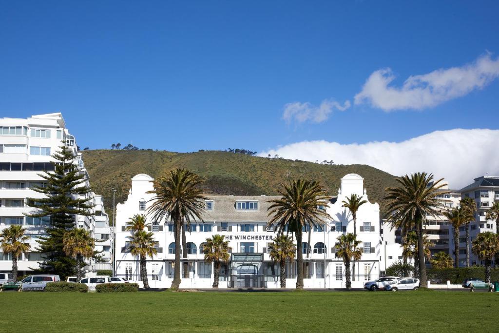 The Winchester Hotel aan de Sea Point Promenade in Kaapstad met uitzicht op de Atlantische Oceaan en de bergen op de achtergrond.