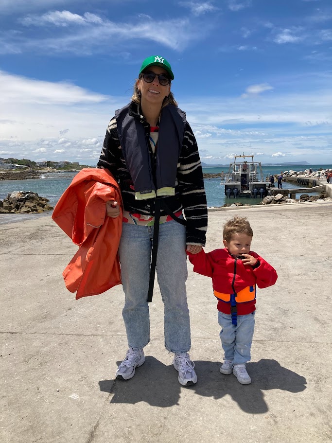 Roxanne en Elliot dragen een zwemvest op de kade van Hermanus voordat ze aan boord gaan van een walvisboot.